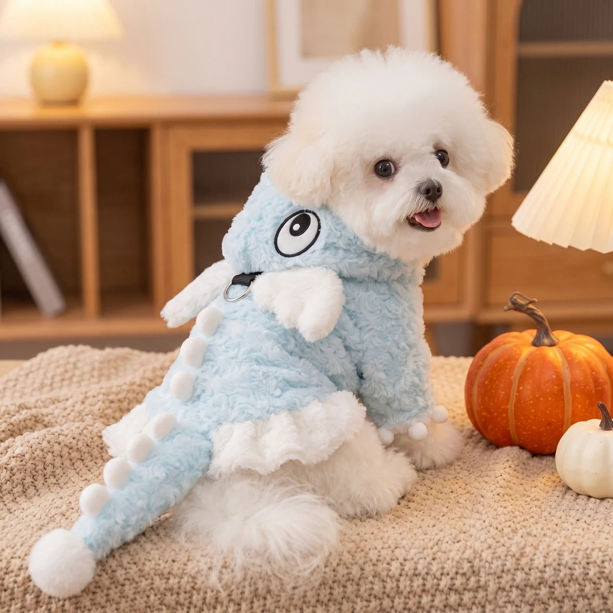 Hund im blauen Dino-Kostüm zu Hause mit Kürbisdeko
